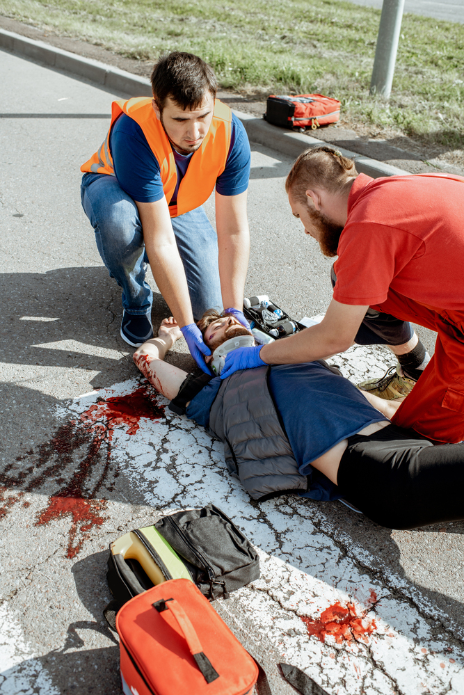 Medics applying emergency care to pedestrian after accident