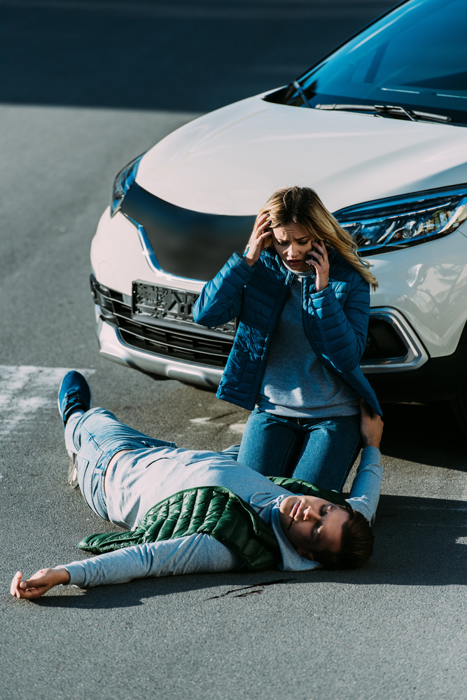 Scared young woman looking at pedestrian after accident
